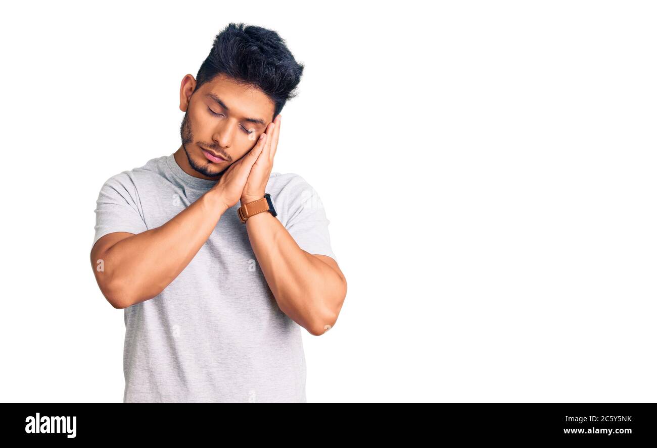 Handsome latin american young man wearing casual tshirt sleeping tired ...