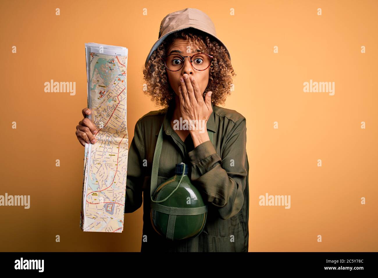 African american tourist woman wearing explorer hat and water canteen ...