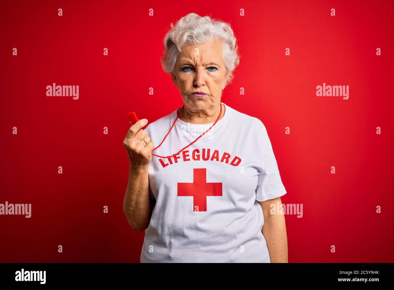 Senior beautiful grey-haired lifeguard woman wearing t-shirt with red ...