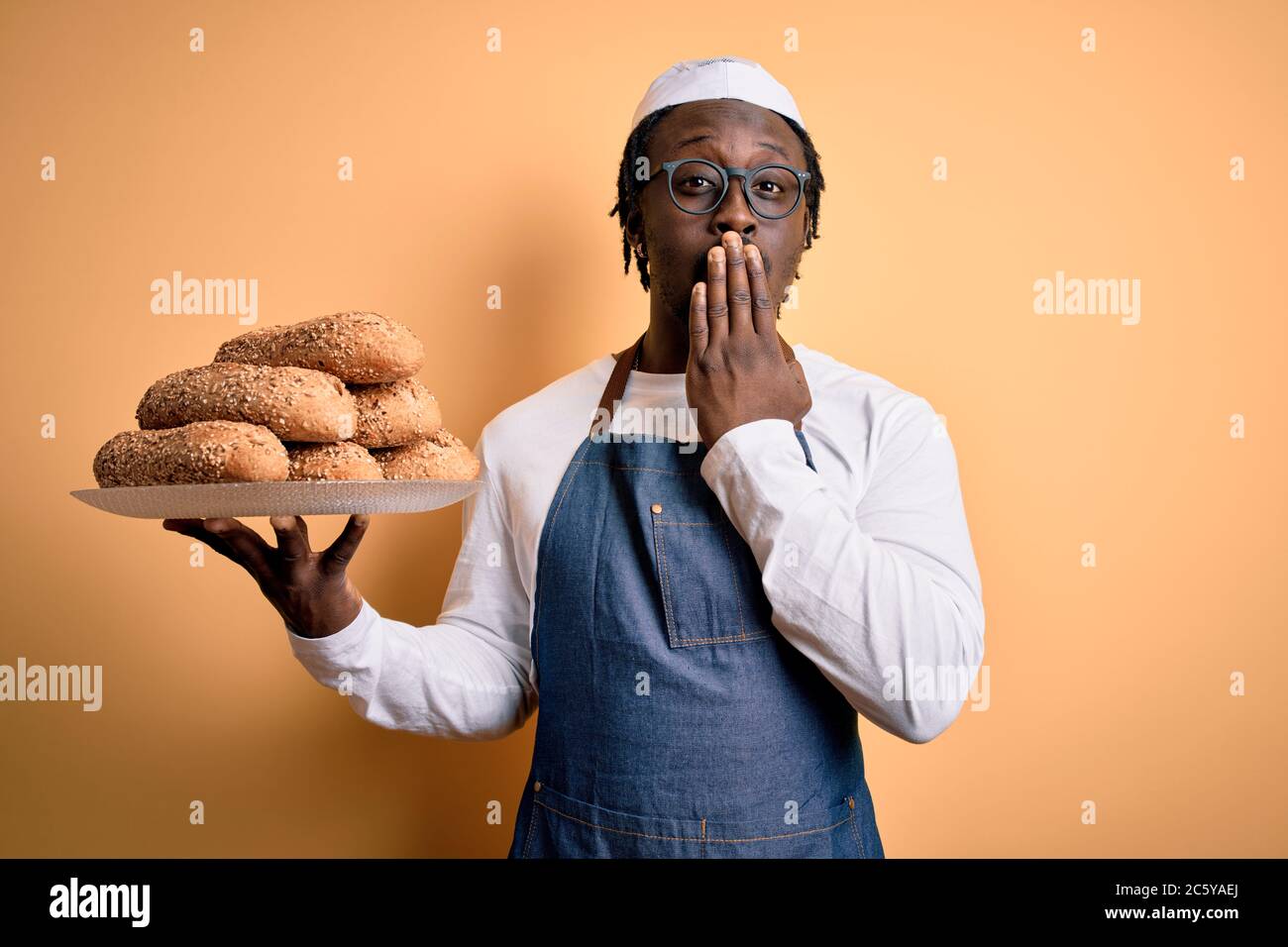 Young african american bakery man holding tray with healthy wholemeal