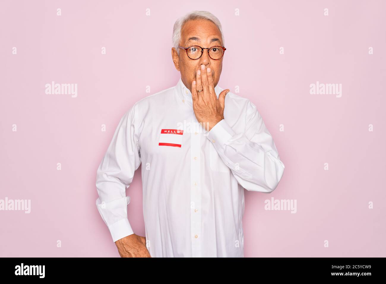 Middle age senior grey-haired man wearing hello my name is introduction ...