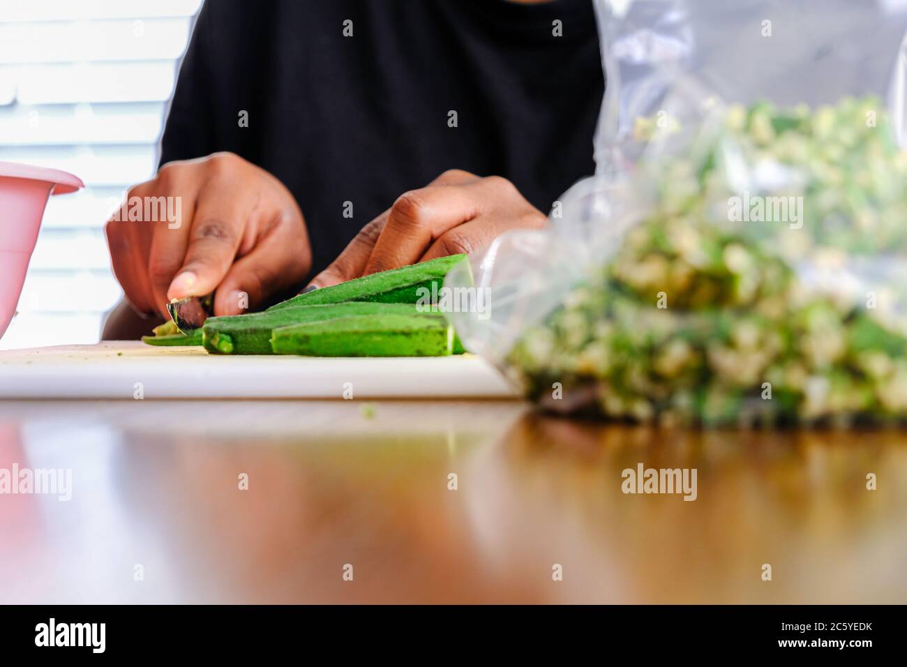 Woman Preparing Nigerian Okra Okra for storage in a fridge Stock Photo