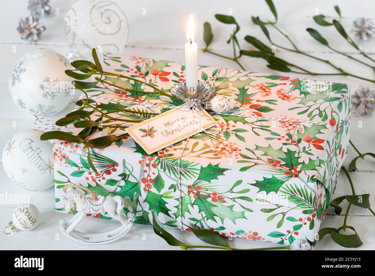 christmas present box decorated wirh mistletoe and candle Stock Photo