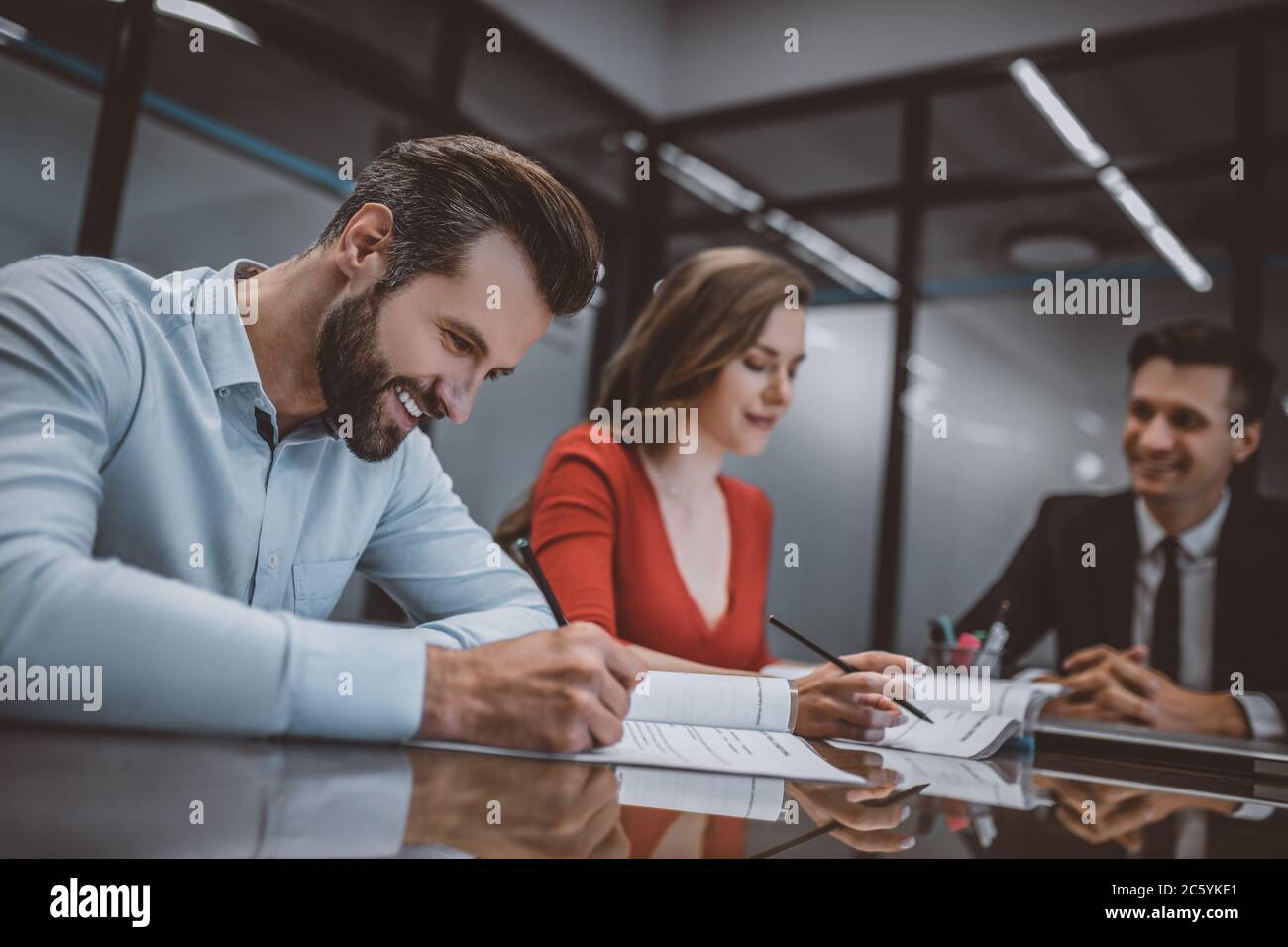 Smiling man signing a document together with his wife Stock Photo