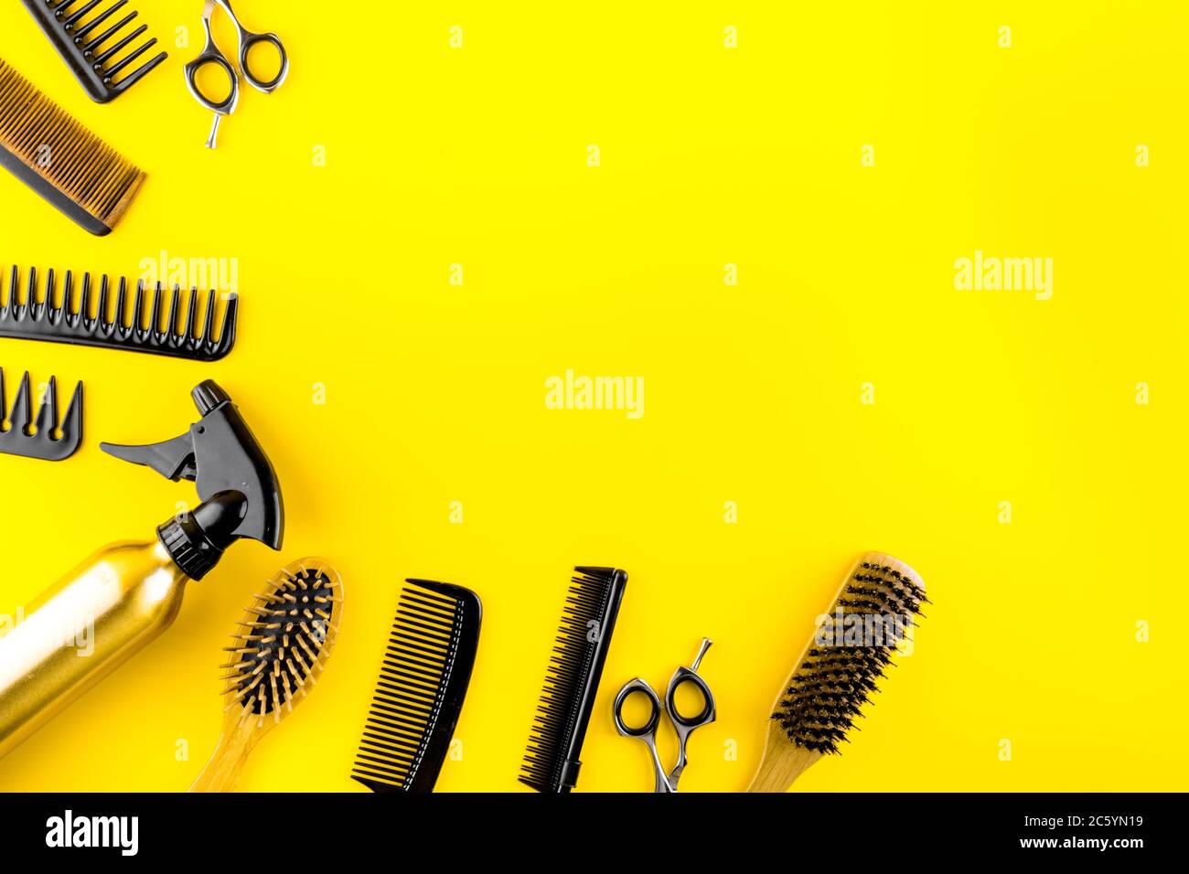 Hairdressing instruments. Combs, scissors on yellow table top view frame copy space Stock Photo