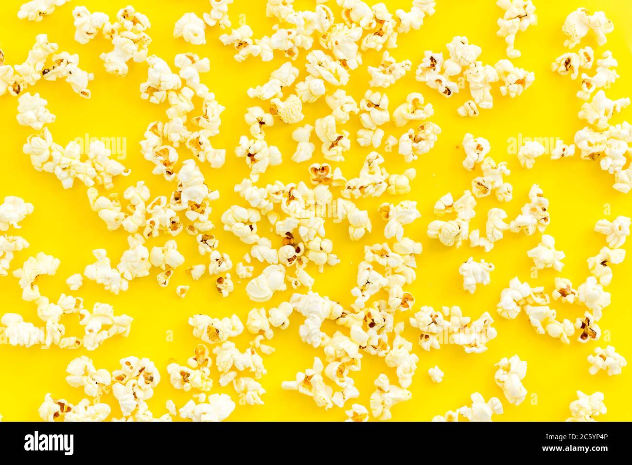 Popcorn scattered on yellow background top view Stock Photo