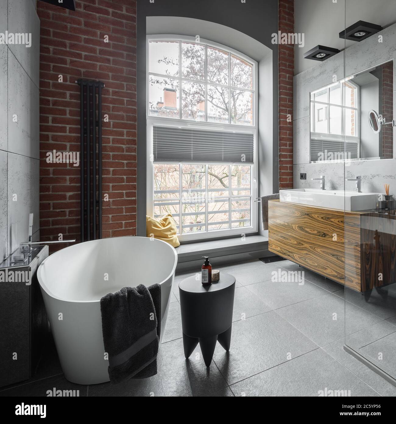 Industrial style bathroom with oval bathtub and big window Stock Photo