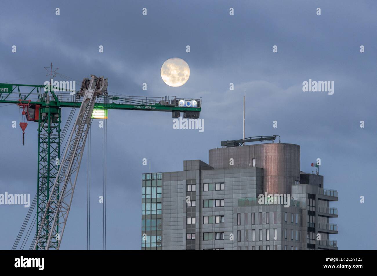 Cork City, Cork, Ireland. 06th July, 2020. A full Moon descends behind the Elysian, Irelands second tallest building in Cork City, Cork Ireland.  - Credit; David Creedon / Alamy Live News Stock Photo