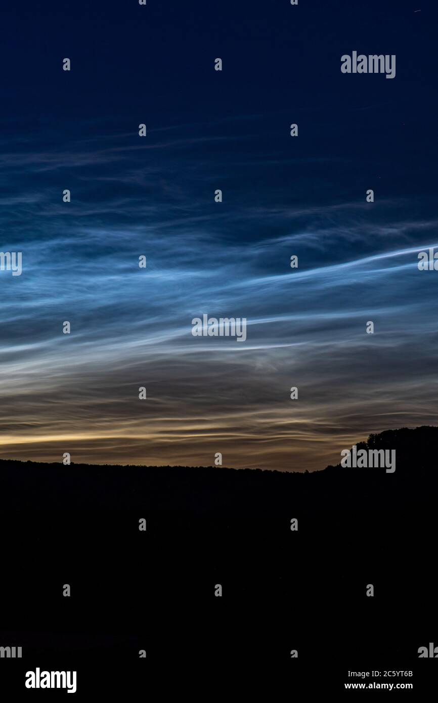 A rare phenomenon: noctilucent clouds. These clouds are so high, about 80km. dark forest Stock Photo