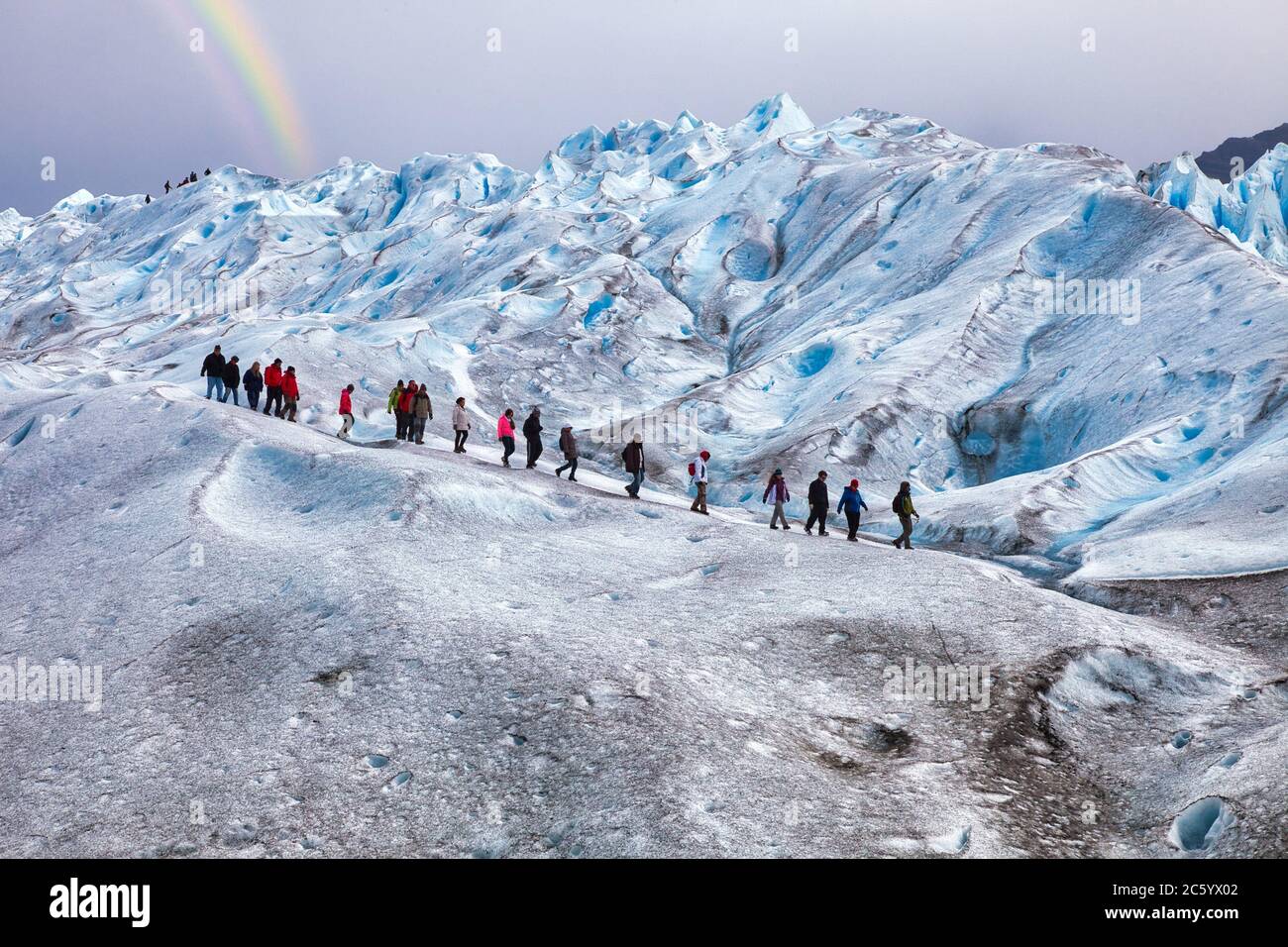 Person Walking On Glacier Ice Surface Wearing Crampons Stock Photo