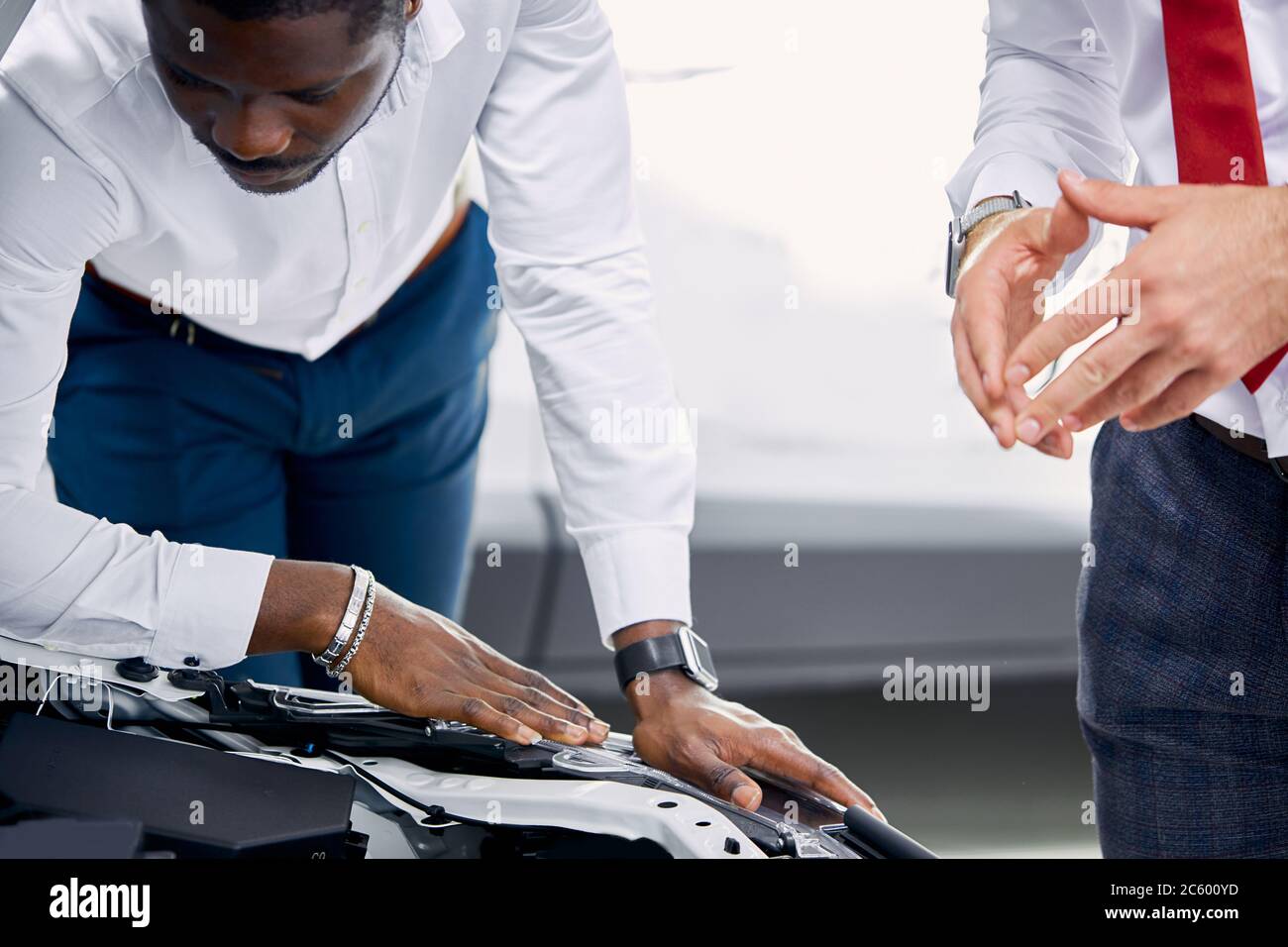 confident professional salesman talk about characteristics of car to