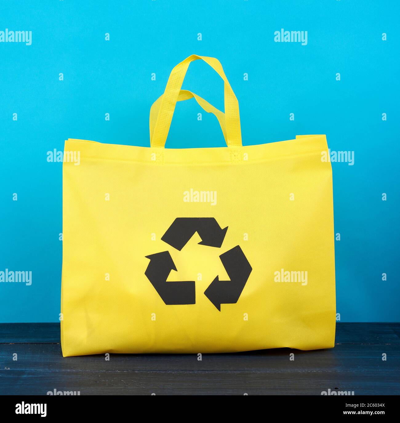 https://c8.alamy.com/comp/2C6034X/full-reusable-yellow-viscose-bag-on-blue-wooden-background-plastic-waste-reduction-concept-2C6034X.jpg