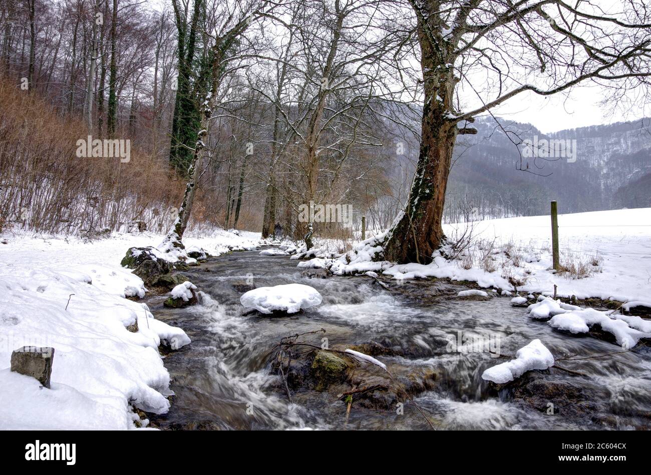 Small mountain stream in winter with ice sheets, Bruehlbach, Bad Urach, Baden-Wurttemberg, Germany. Stock Photo