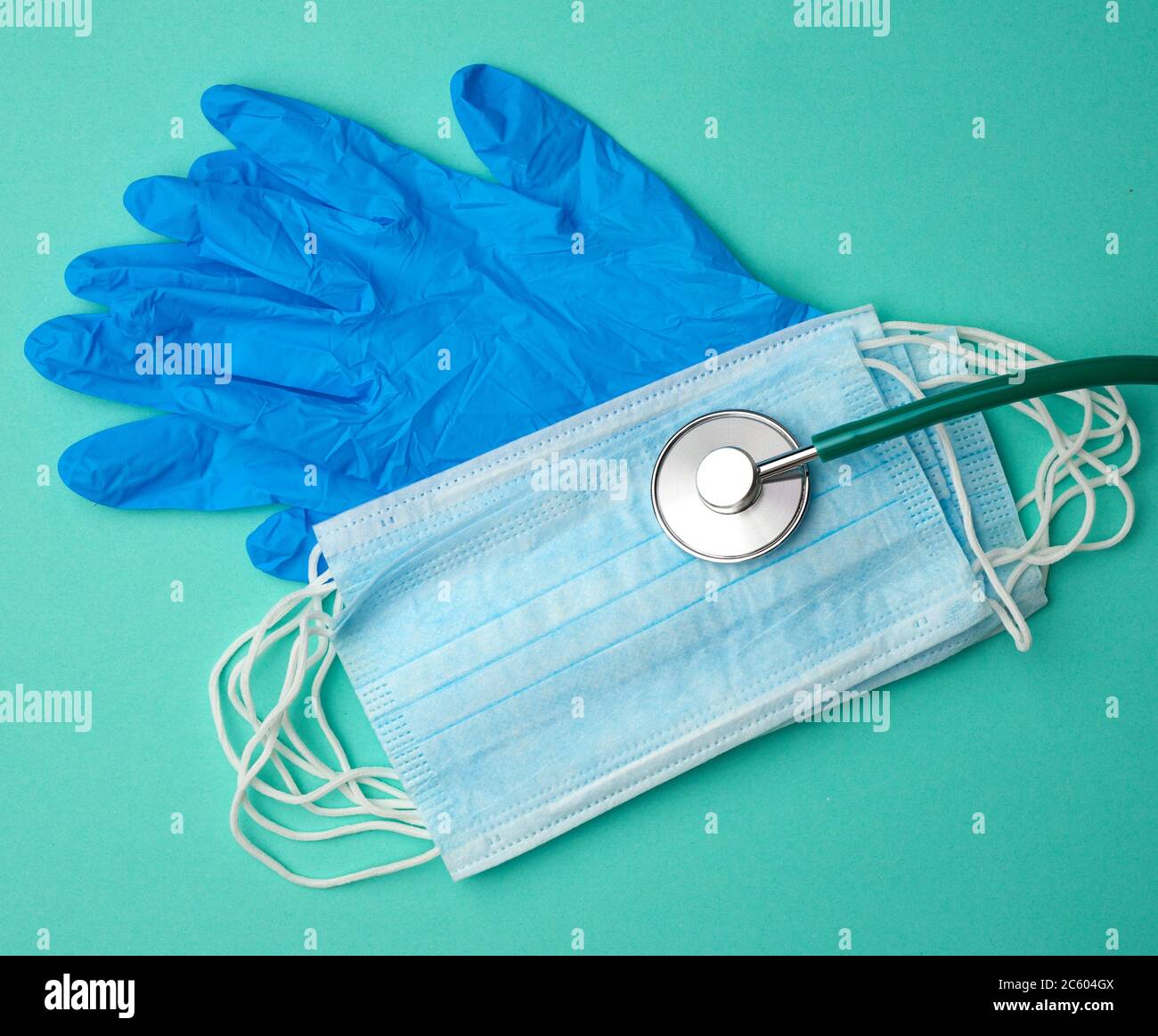 blue latex gloves and disposable masks on a green background, hygiene