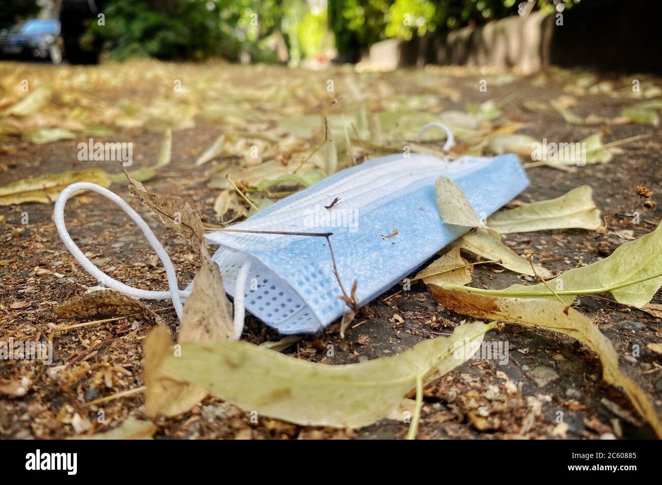 Berlin, Germany. 06th July, 2020. A mouth and nose protector lies in the leaves on a sidewalk in Berlin-Friedenau. Credit: Kay Nietfeld/dpa/Alamy Live News Stock Photo