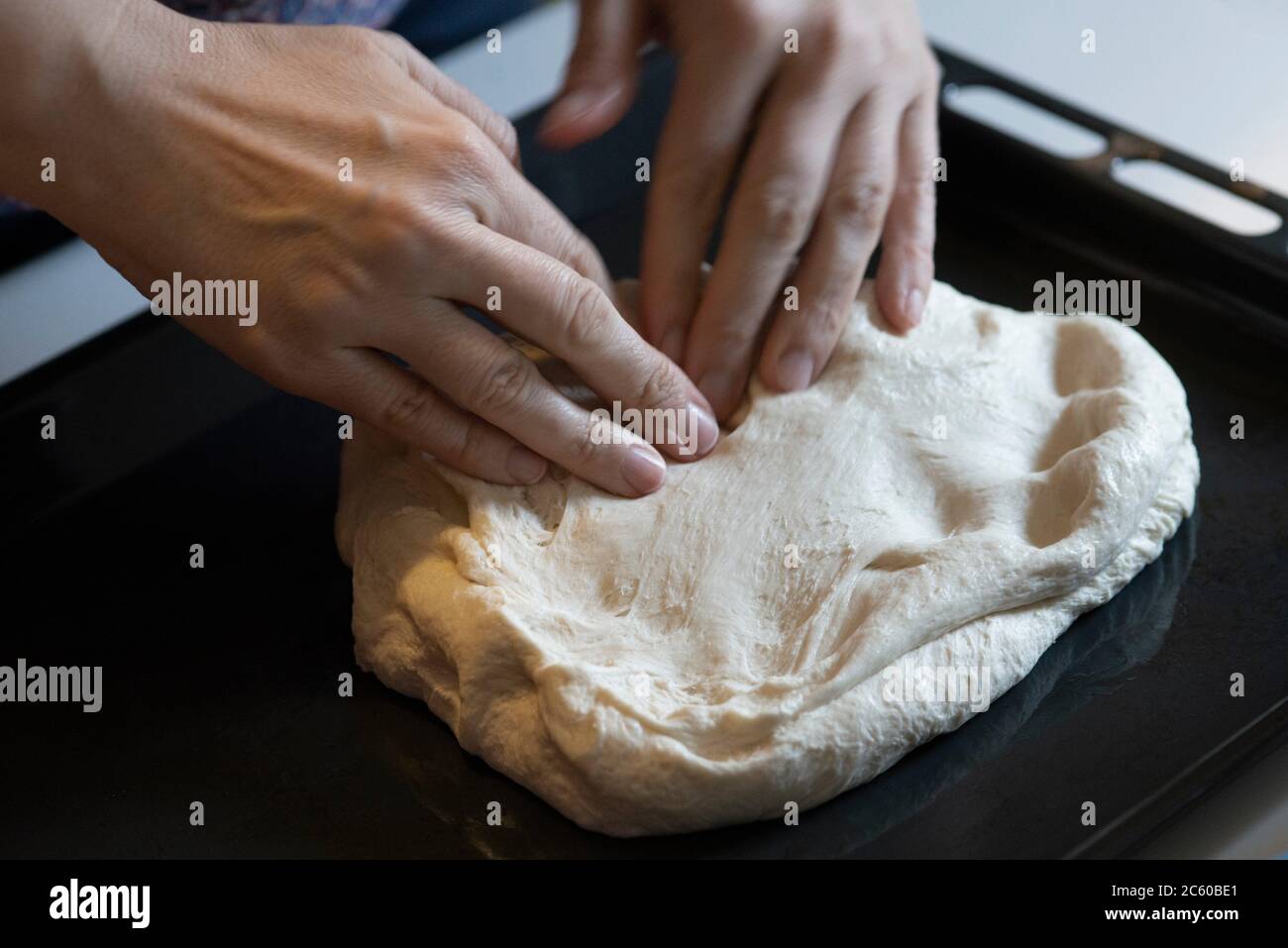 Pressing Pizza Dough Into Oven Tray Stock Photo Alamy