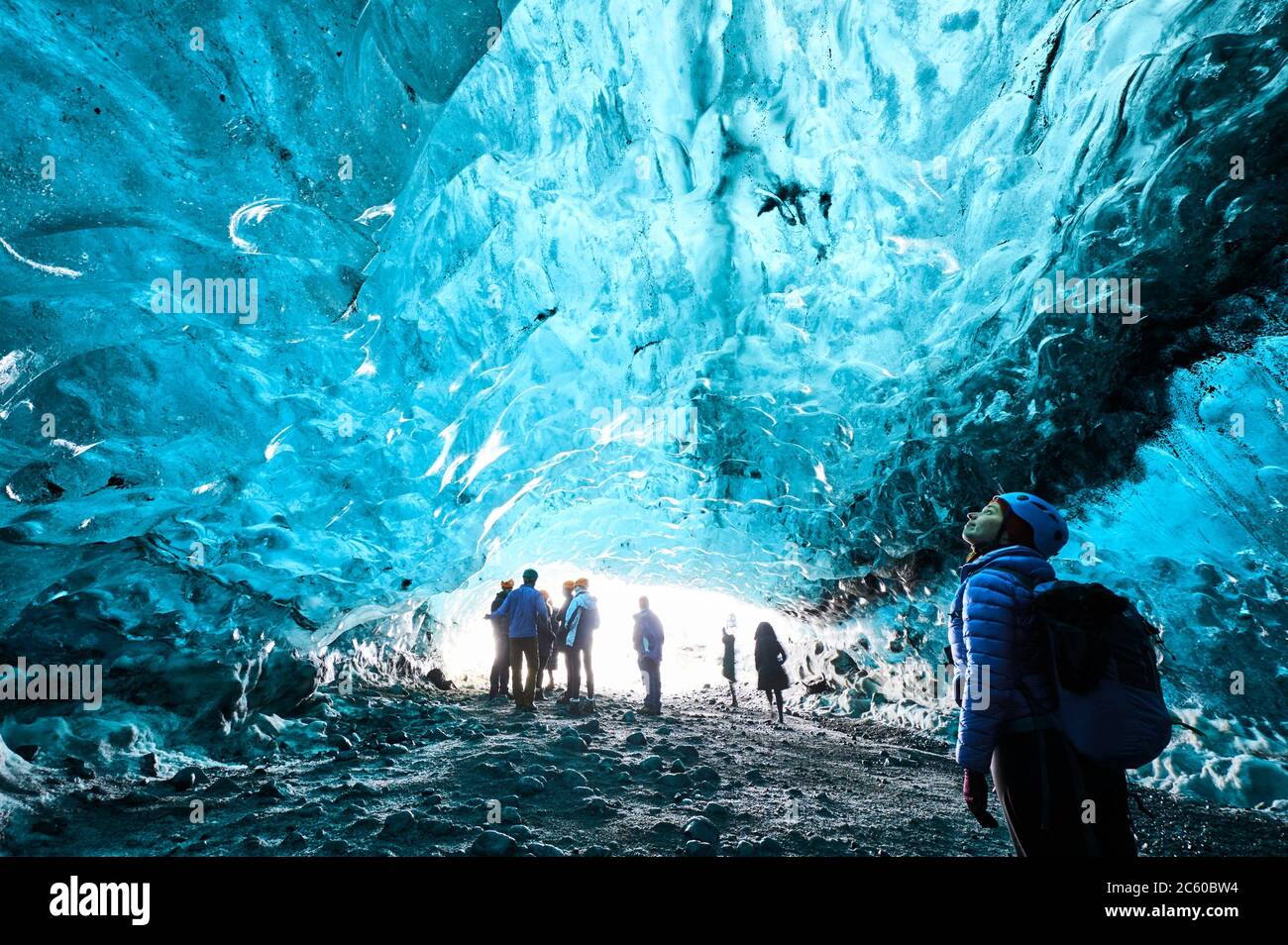 Tourists exploring a ice cave in Breidamerkurjökull glacier, which is an outlet glacier of the larger glacier of Vatnajökull (region of Austurland, Stock Photo