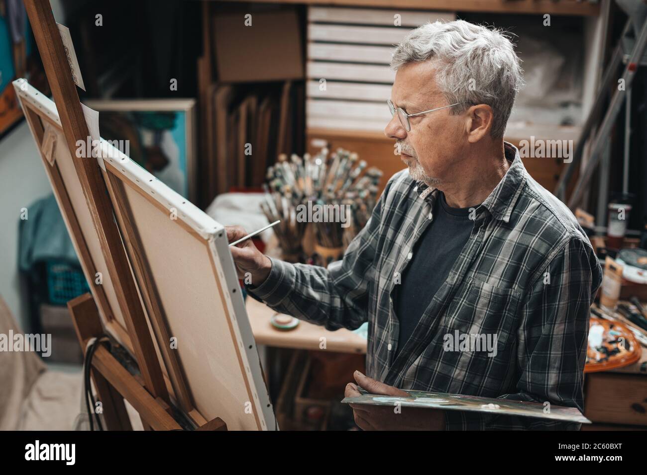 Senior artist painting in his studio Stock Photo