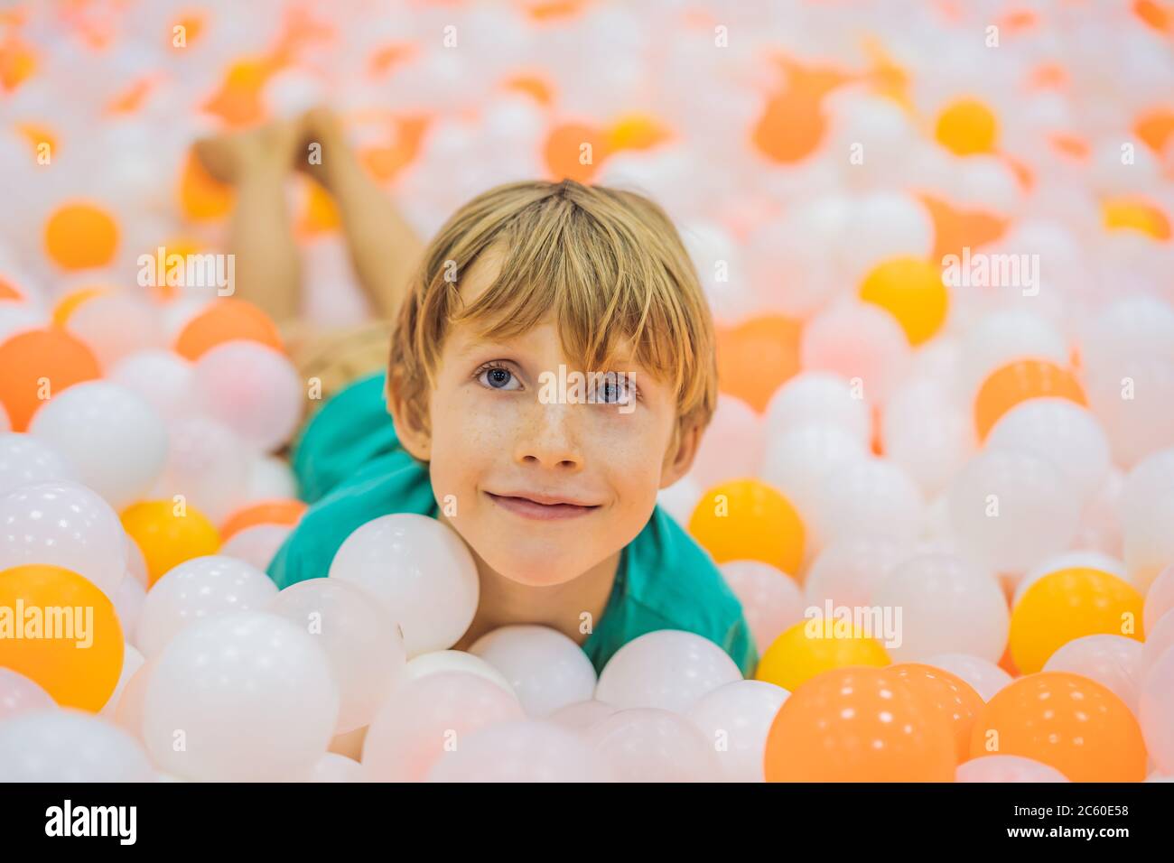 Child playing in ball pit. Colorful toys for kids. Kindergarten or