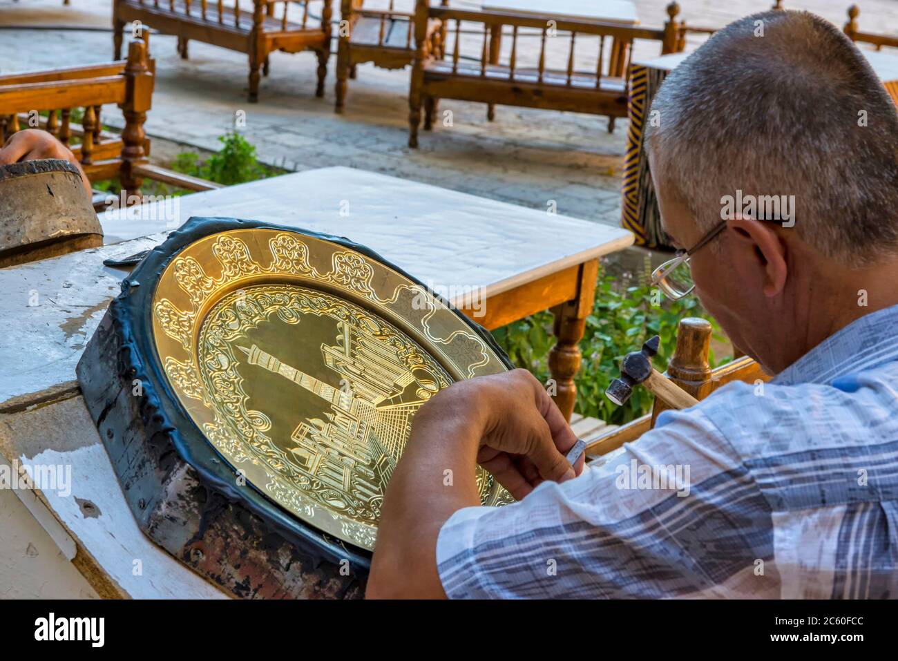 Bukhara, Uzbekistan. Artisans carve into metal plates in the historical