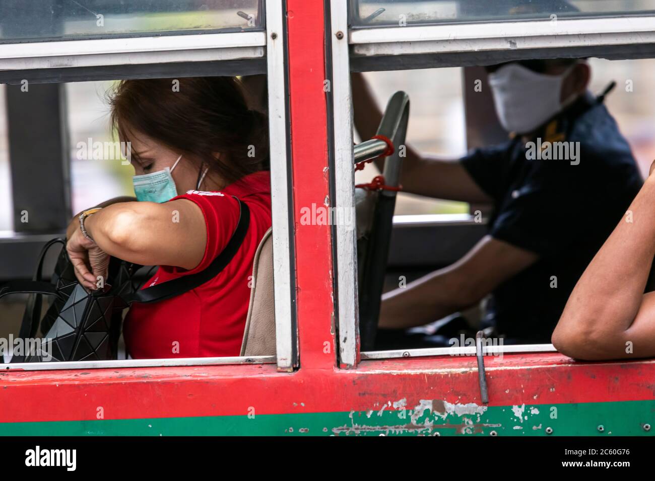 Bus passenger wearing face mask during covid 19 pandemic, Bangkok, Thailand Stock Photo