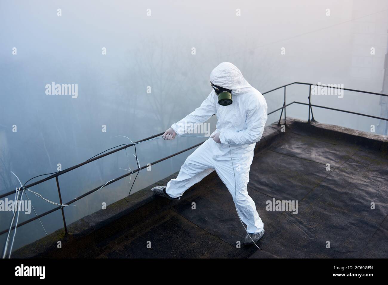 Scientist working on the roof of a high storey building, wearing ...
