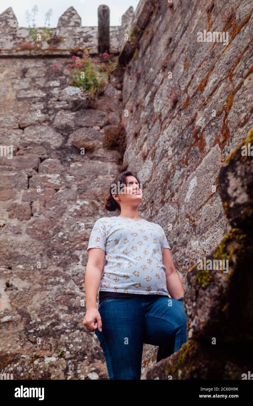 Pregnant woman climbing the stairs of the Soutomaior castle in Galicia