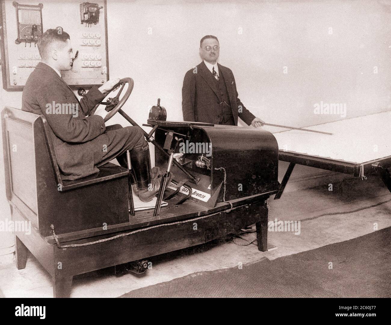 A man in a car simulator that turns on the brakes, gas, and clutch. Weimar Republic. Germany, Leipzig, 1926 Stock Photo