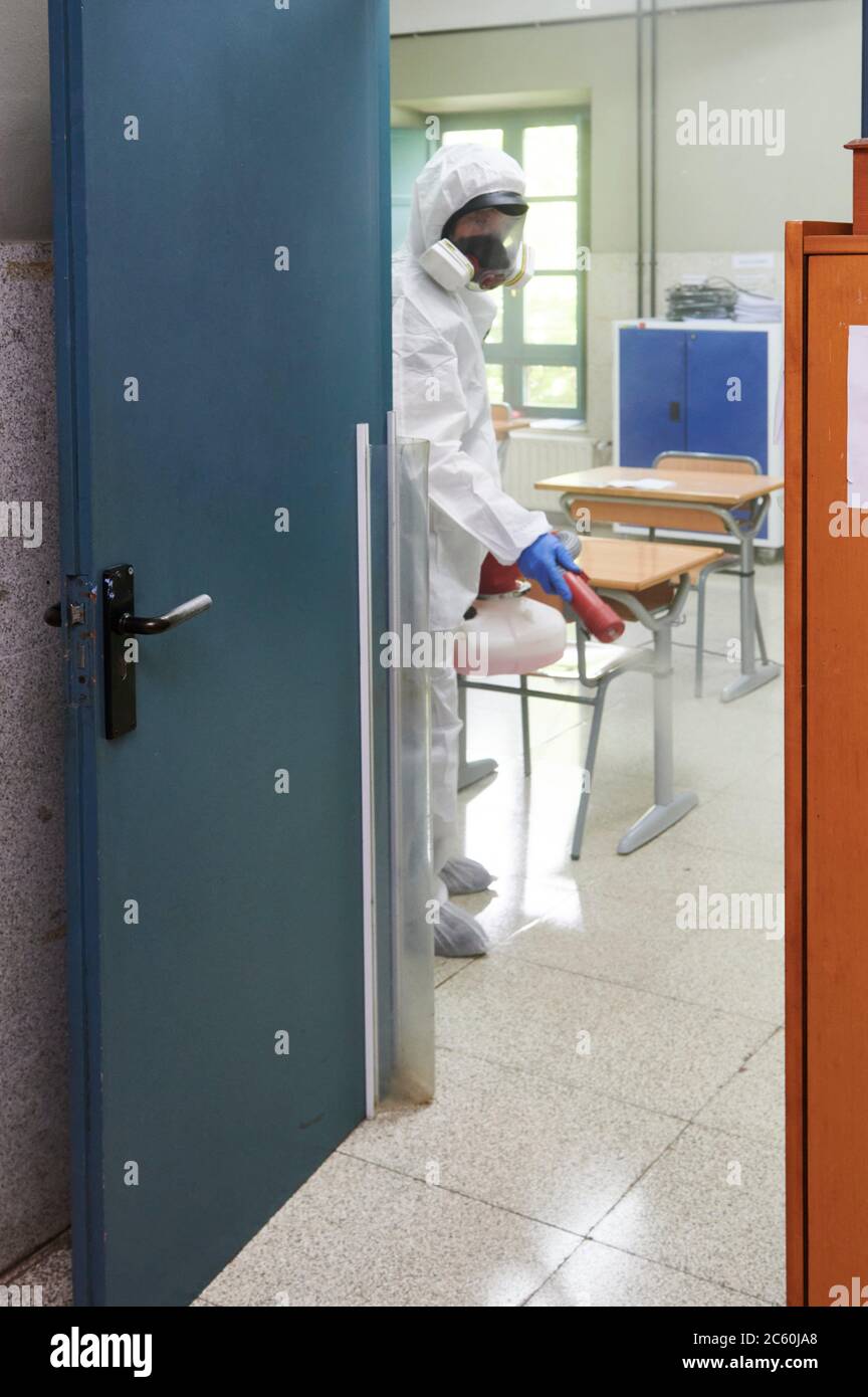 Worker in protective suit disinfect interior of the school. Stock Photo