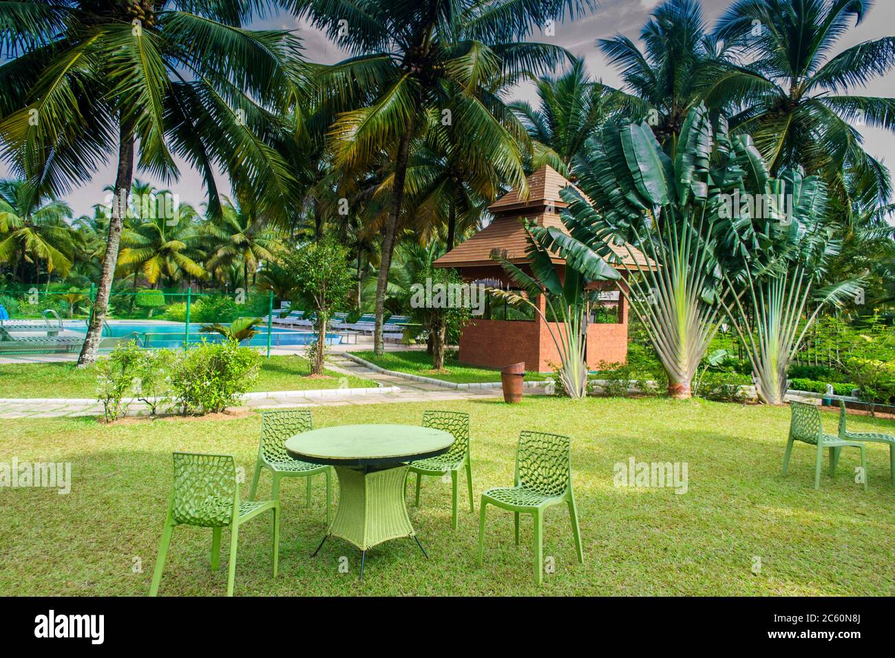chairs and table in a lawn of a resort on the bank of Vembanad lake Kerala Stock Photo