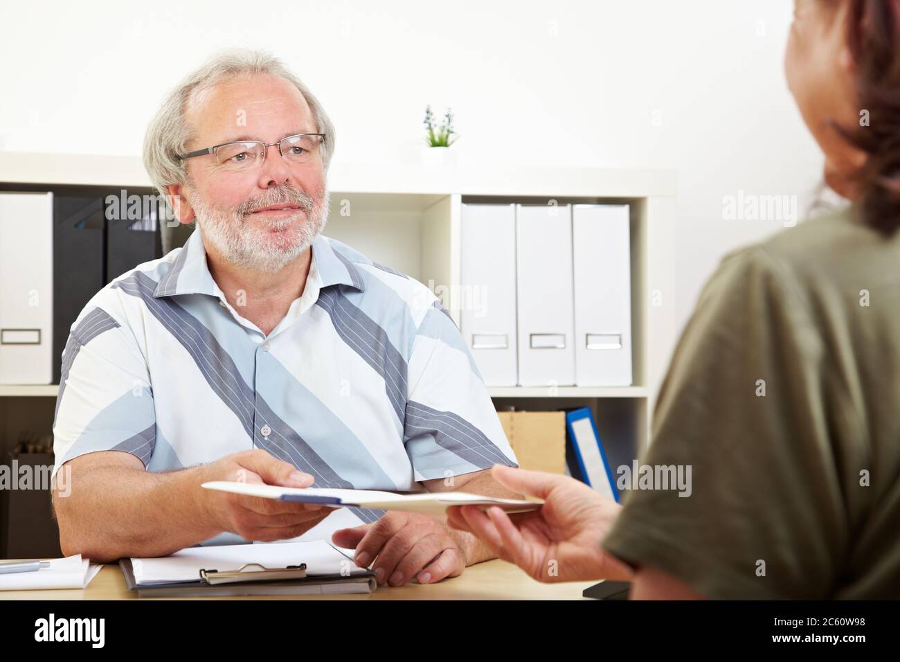 Woman hands over application folder to HR at interview Stock Photo