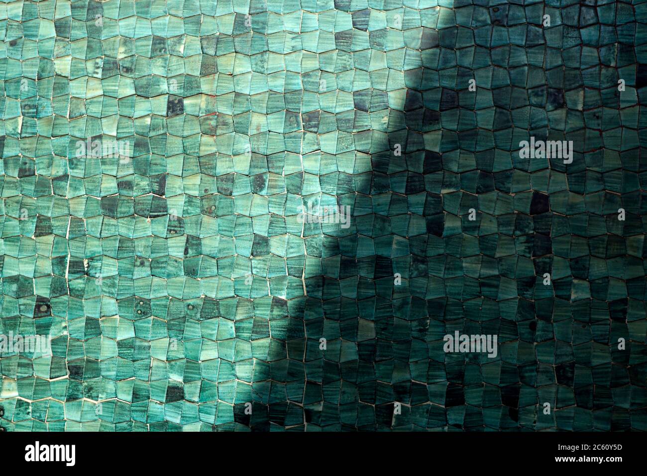 A Close Up Of An Exterior Wall Of A Building In Milan Tiled In Small Green Tiles And Half In Shadow Stock Photo
