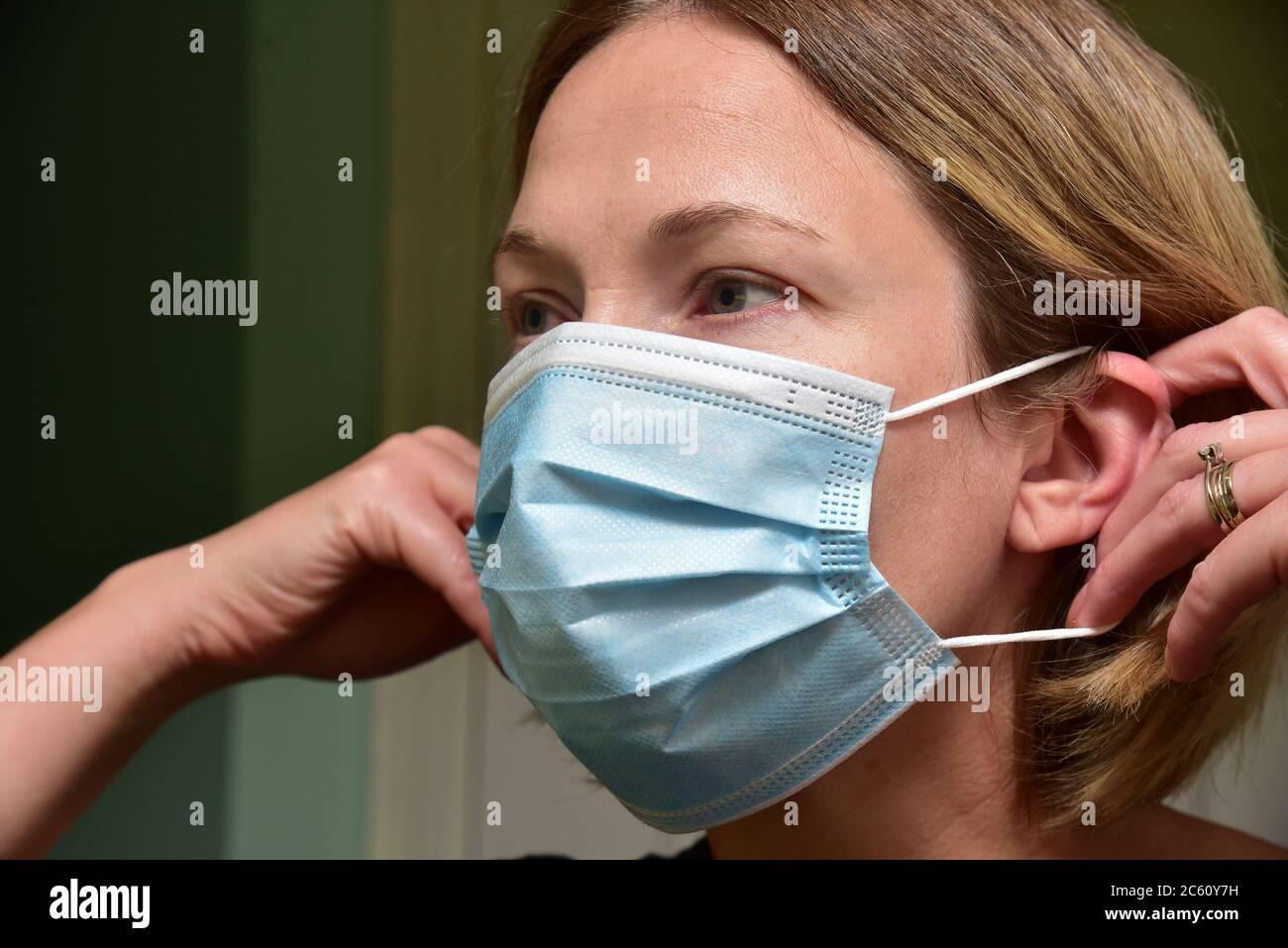 FRSM or Fluid Surgical Mask is modelled by a NHS employee in the fight against Covid-19. A three-layer mask or surgical mask, the correct way to wear. Stock Photo