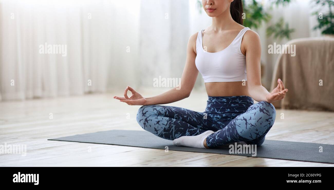 Unrecognizable Sporty Woman Practicing Yoga At Home, Meditating In Lotus Position Stock Photo