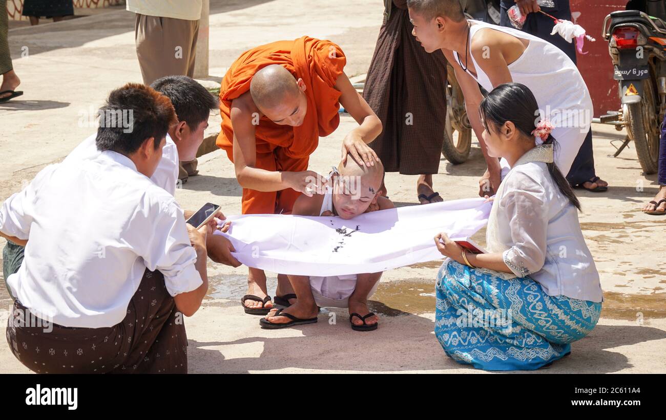 Monk child getting a haircut in public in Kalaw city, Myanmar / Burma. Stock Photo