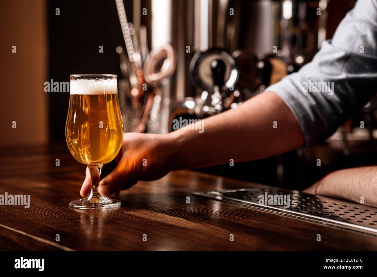 Drinks, fun, meeting, oktoberfest. Barman serves beer on counter in interior of pub Stock Photo