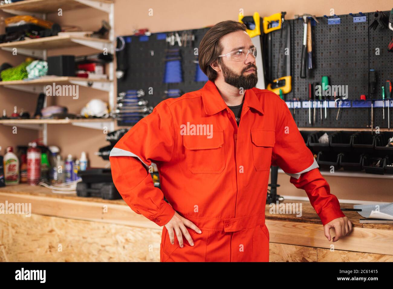 Builder in work clothes and protective eyewear thoughtfully look Stock Photo