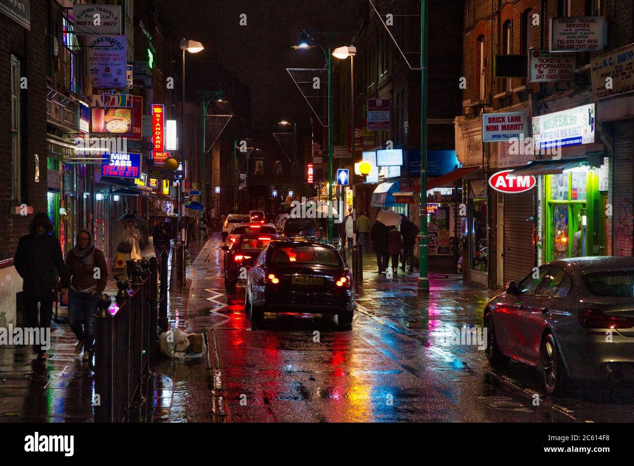 LONDON, UK - APRIL 22, 2016: People walk by ethnic stores and restaurants at night Brick Lane, Shoreditch, London. Shoreditch is known for its multicu Stock Photo