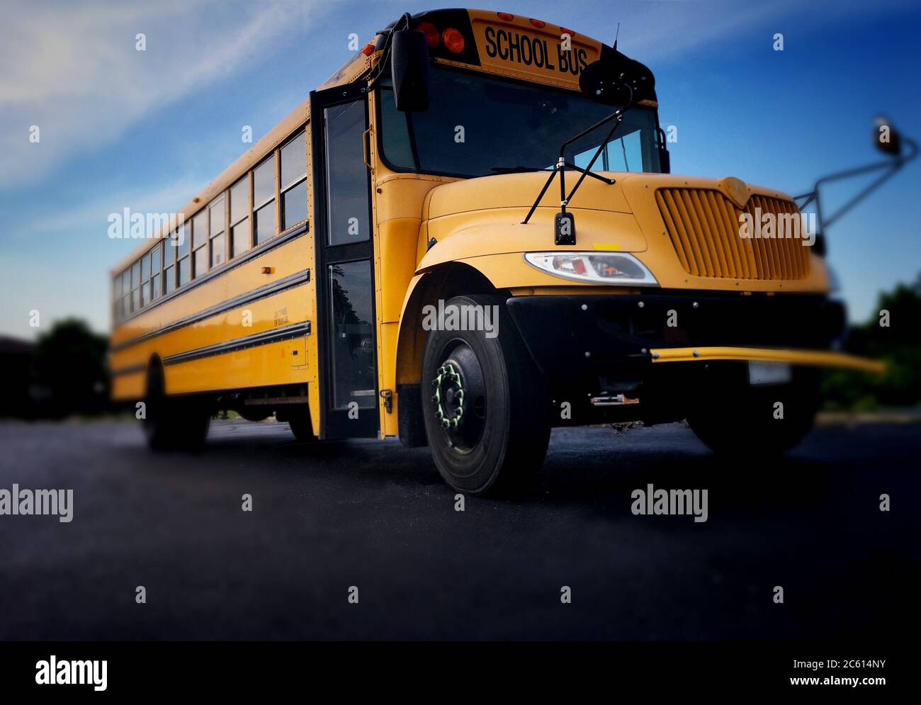 Low angle view of the front door side entrance of a yellow American public school bus used to transport kids to school, field trips and extra circular Stock Photo