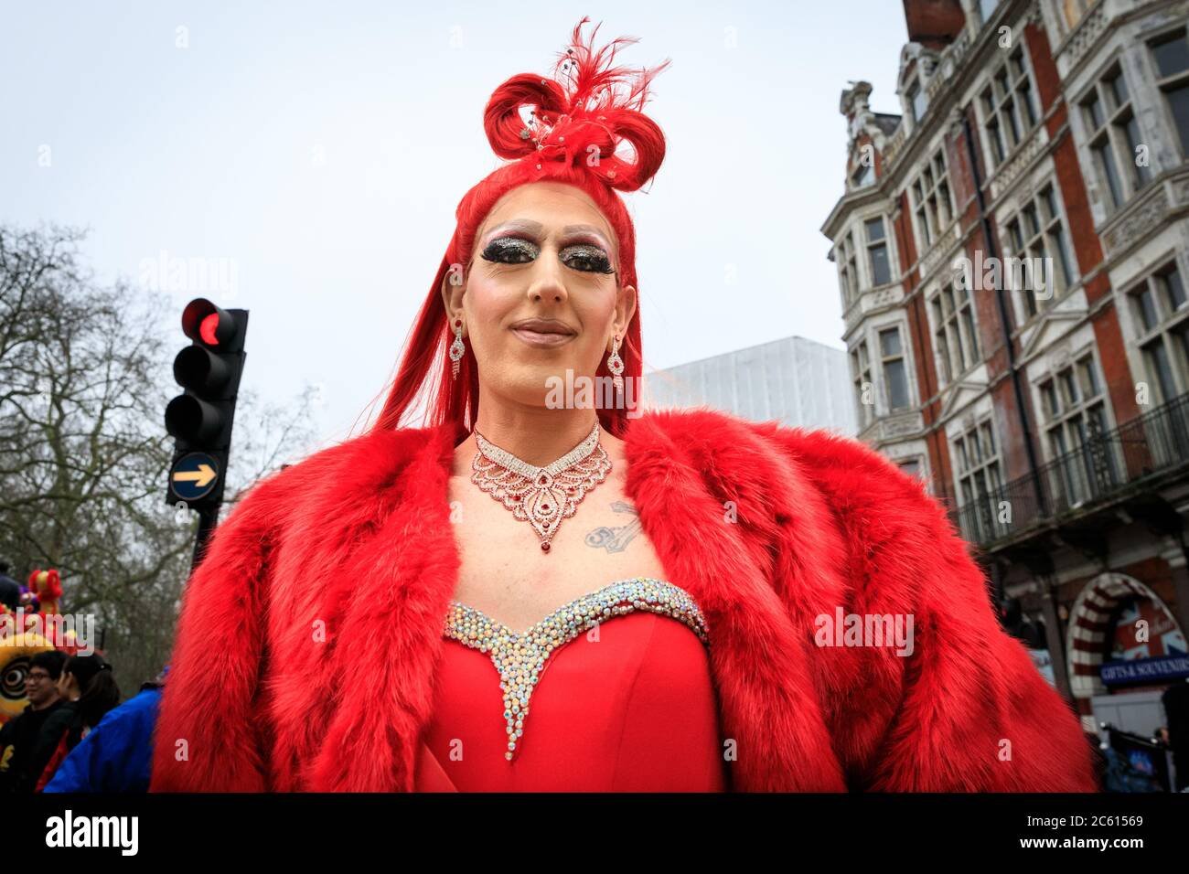 A striking, colourful Priscilla performer in red wig and outfit takes part in London New Year's Day Parade (LNYDP) 2020, London, England Stock Photo
