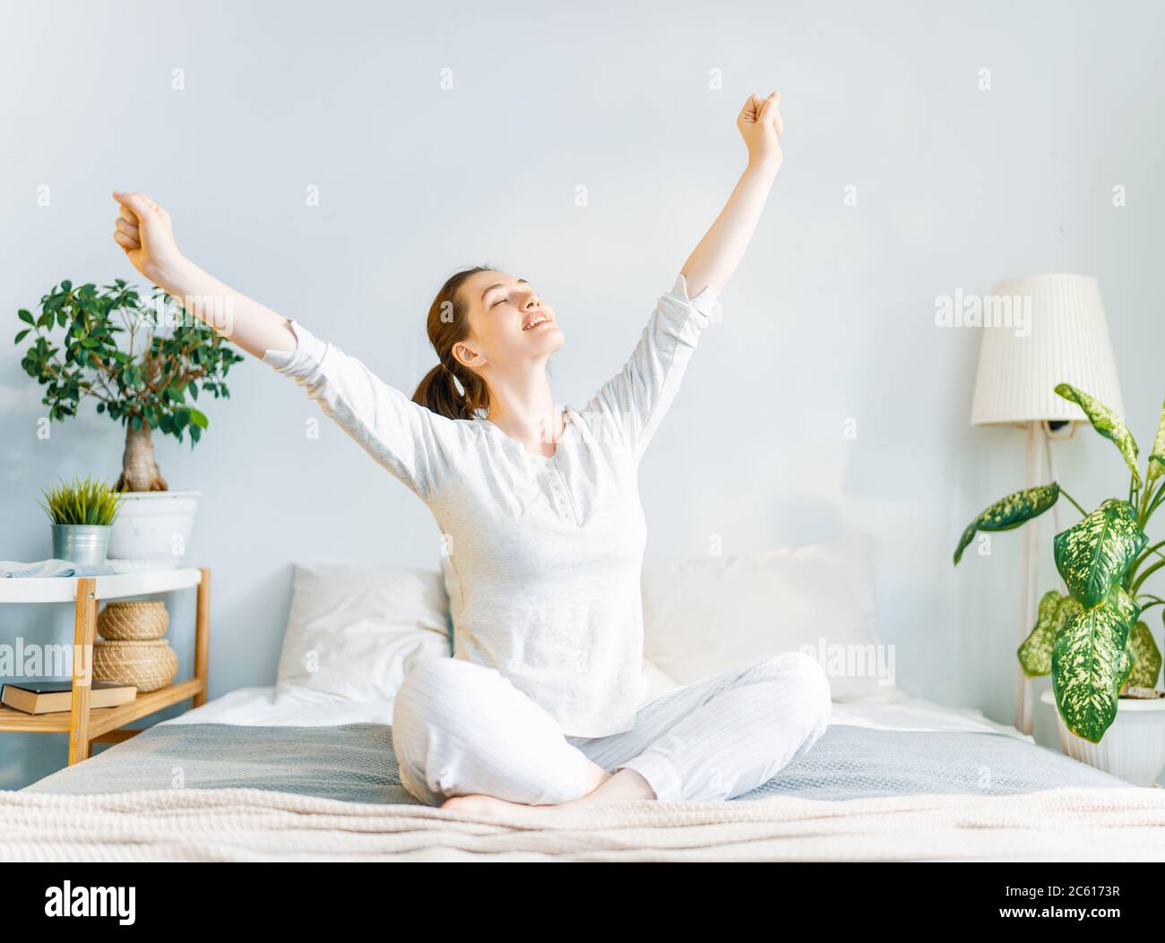 Happy young woman enjoying sunny morning on the bed Stock Photo - Alamy