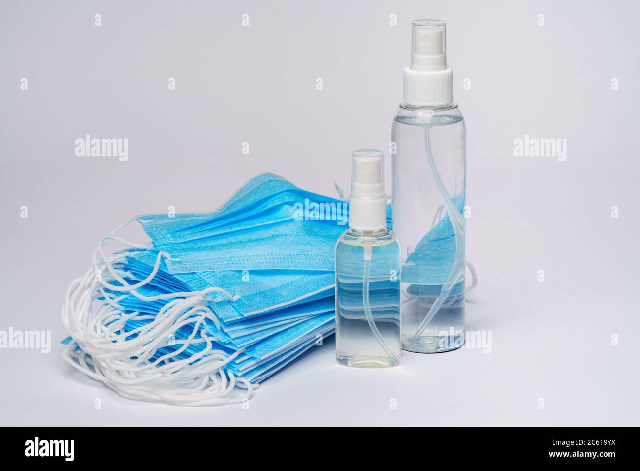 bottle of lotion, sanitizer or liquid soap and protective mask over ...