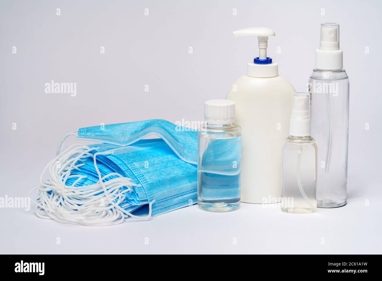 bottle of lotion, sanitizer or liquid soap and protective mask over ...