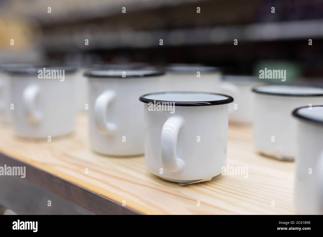 white metal enameled mugs standing on a store counter Stock Photo