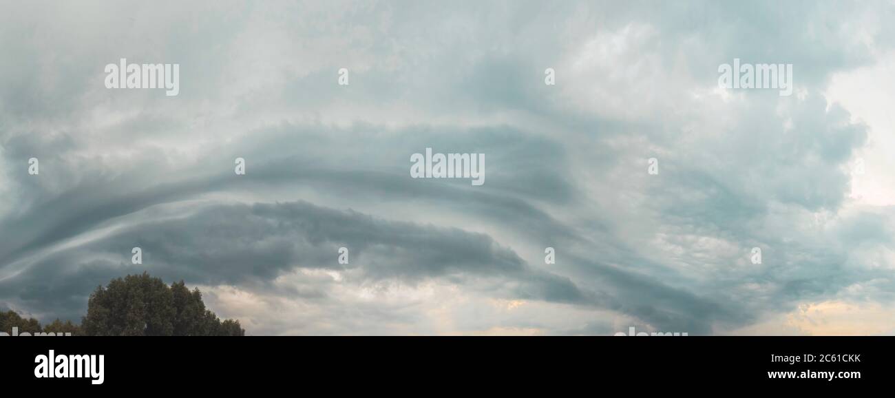 thundercloud rolls across the sky at sunset Stock Photo