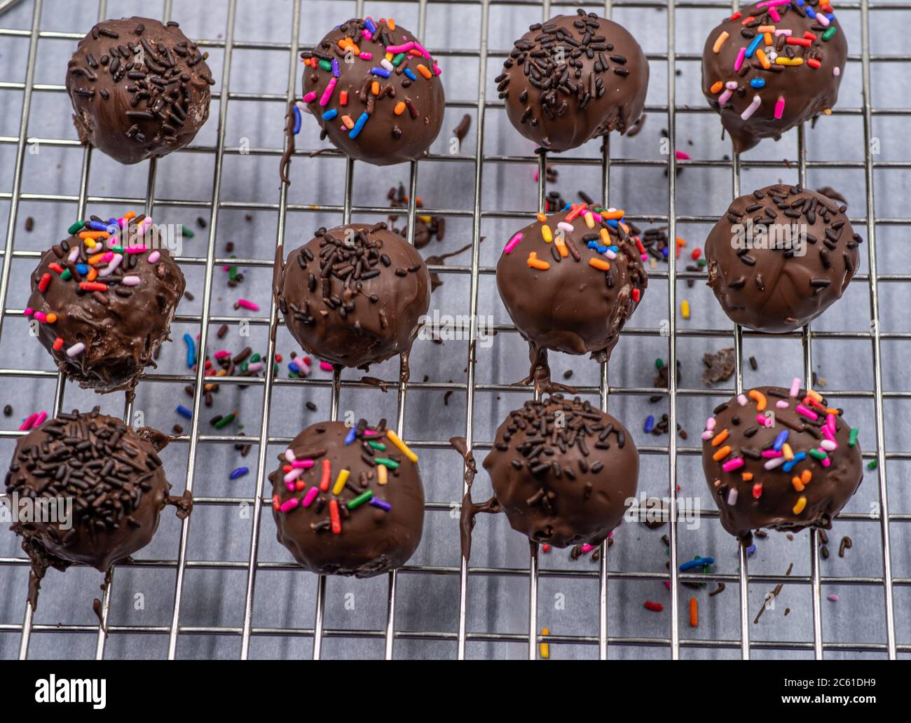 Chocolate donut holes with sprinkles on cookie rack Stock Photo Alamy