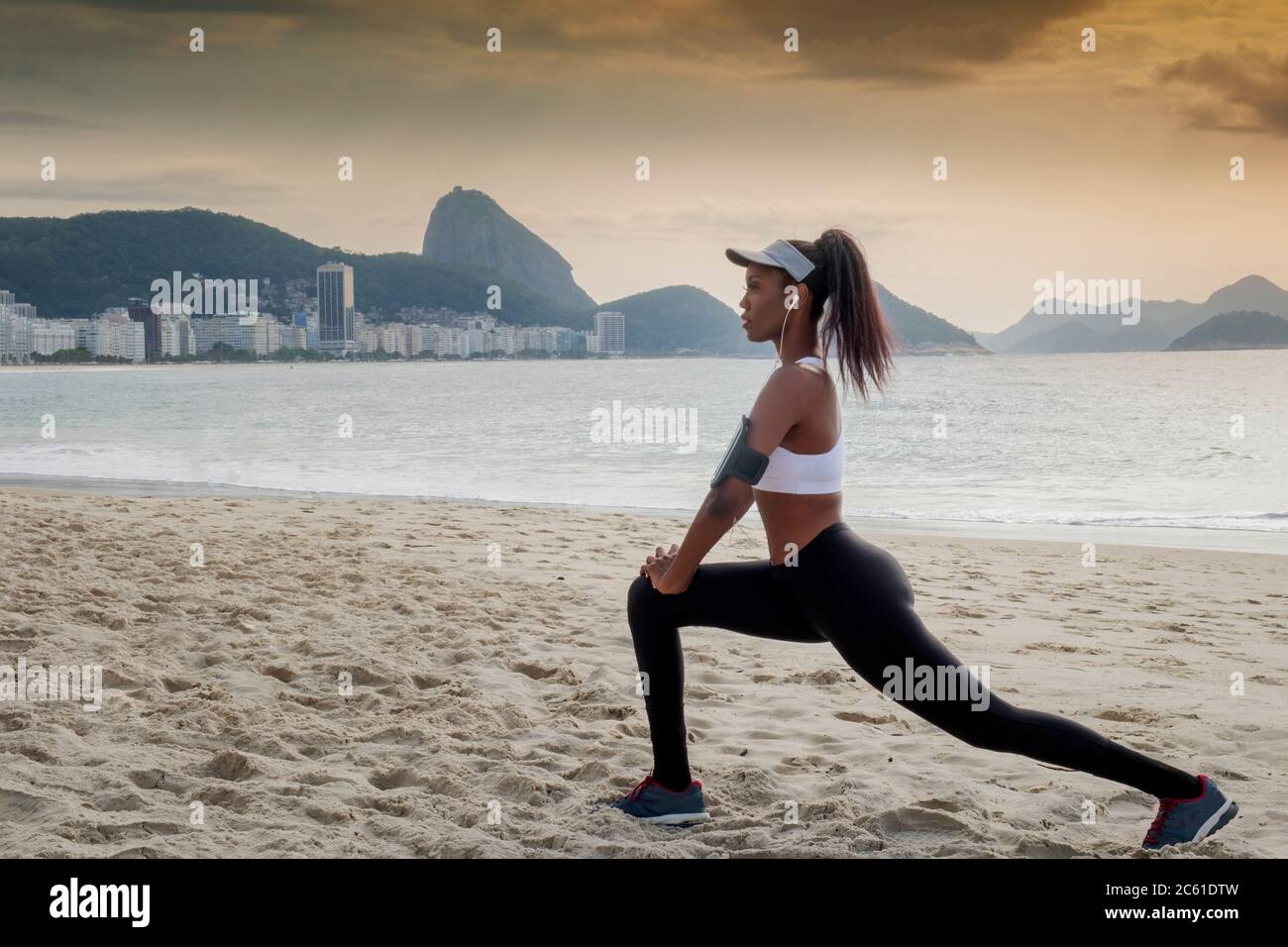 South America, Brazil, Copacabana Beach. A black Brazilian woman in her early thirties stretching before a run Stock Photo