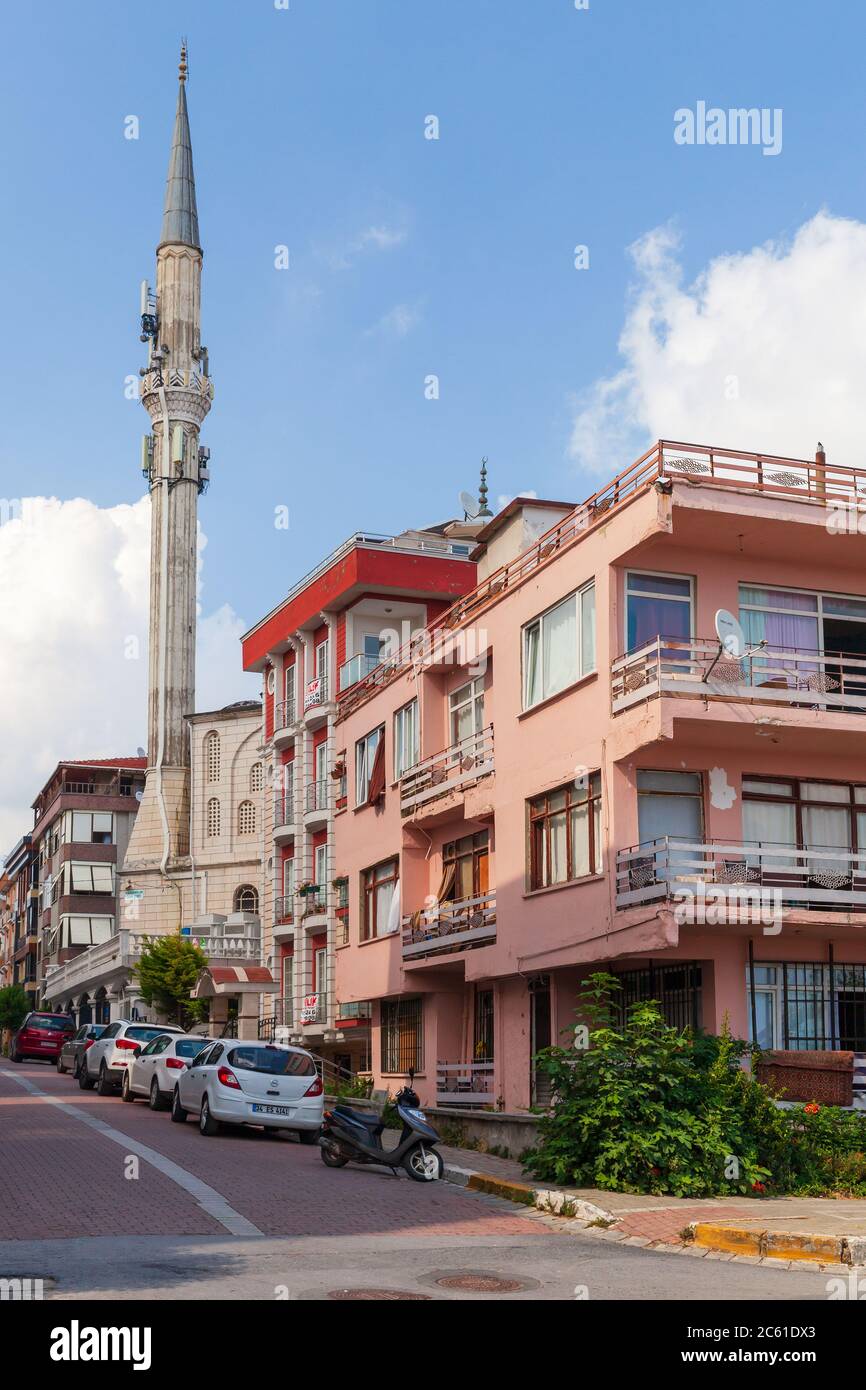 Istanbul, Turkey - June 30, 2016: Narrow street in Istanbul with mosque, cars are parked on the roadside, vertical photo Stock Photo
