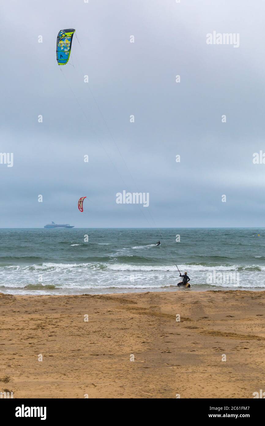 kite surfers kite surfing at Bournemouth, Dorset UK on windy drizzle day in July kitesurfers kite surfer kitesurfer kitesurfing Stock Photo