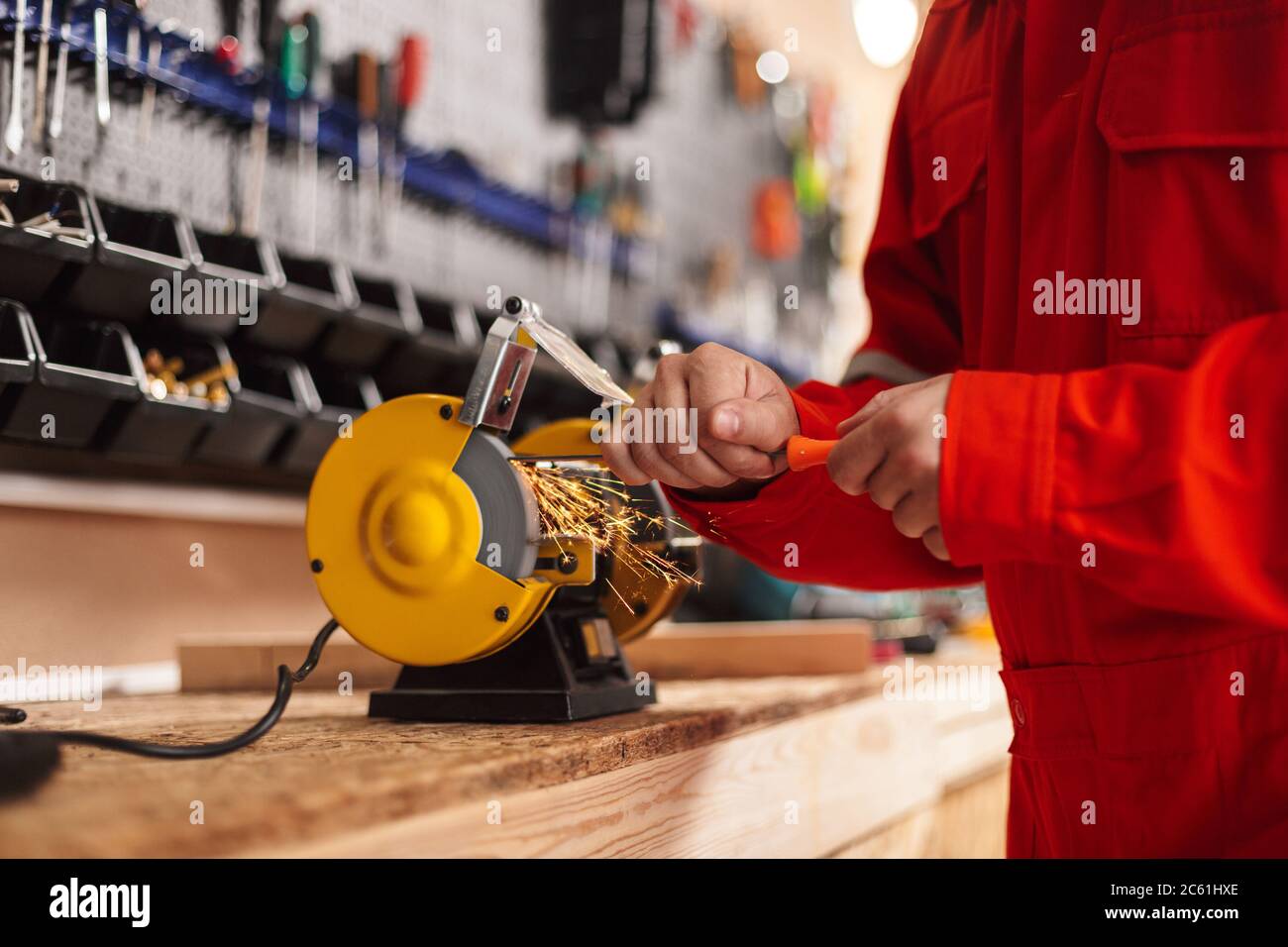 Close up builder using knife sharpener in workshop isolated Stock Photo
